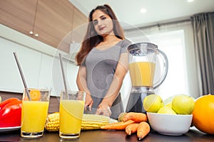 Young happy indian woman making healthy drinks on juicer smoothie jar in modern home