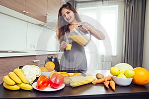 Young happy indian woman making healthy drinks on juicer smoothie jar in modern home