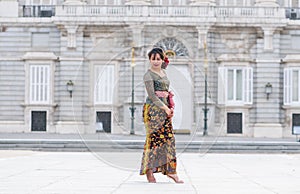 Young happy Indonesian woman from Bali having vacation in Europe - beautiful and exotic Balinese tourist girl dancing in