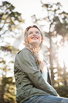 Young happy jogger sitting on rock and looking away