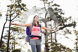 Young happy jogger standing on rock feeling free