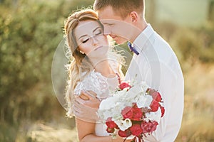 Young happy just married couple posing on the top of the mountain