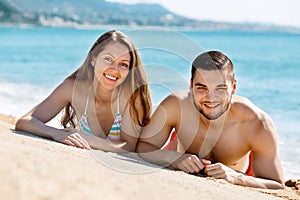 Young happy lovers sunbathing