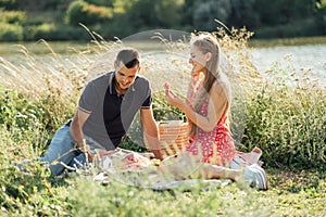 Young happy loving couple embracing and having fun together outdoors. Young couple in love on summer picnic