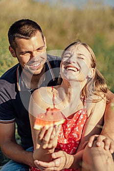 Young happy loving couple embracing and having fun together outdoors. Young couple in love on summer picnic