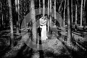 Young happy loving couple enjoy a moment of happiness in forest. Black and white.