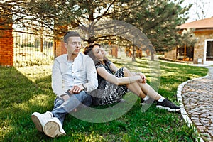 Young, happy, loving couple, sitting together on the grass in the Park, and enjoying each other, advertising, and inserting text