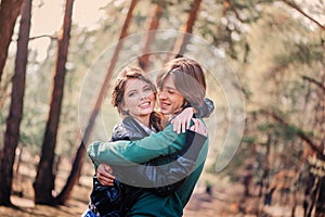 Young happy loving couple on the walk in sunny forest