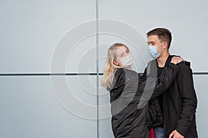 Young, happy, loving couple wearing masks and hugging