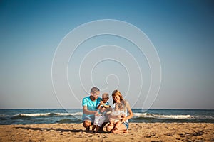 Young happy loving family with small kids having fun at beach together near the ocean, happy lifestyle family concept