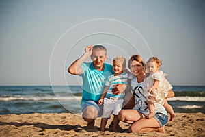 Young happy loving family with small kids having fun at beach together near the ocean, happy lifestyle family concept