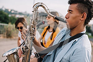Young happy male and female buskers playing music photo