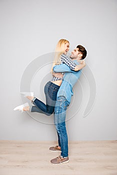 Young happy man carrying his pretty girlfriend