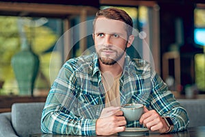 Young happy man with cup of coffee