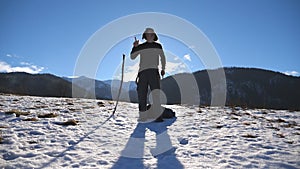 Young happy man dances funny at the winter mountains. Guy dance against the background of snowy landscape. Male tourist