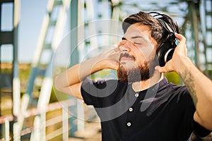 The young happy man listen to the music from the headphones