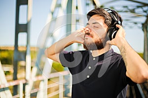 The young happy man listen to the music from the headphones