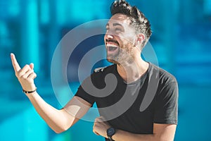 Young happy man pointing up laughing