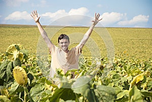 Young happy man in a sunflower field