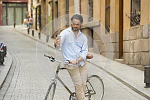 Young happy man taking selfie with mobile phone on retro cool vintage bike