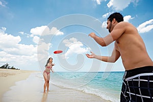 Young happy man and woman playing with frisbee