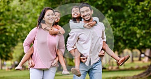 Young happy mixed race family relaxing and walking together in a park. Loving hispanic parents giving their daughters a