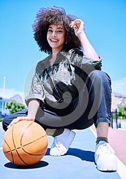 Young happy mixed race female basketball player standing on the court getting ready to play. Hispanic female basketball