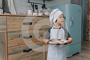 Young happy mom and her baby cook cookies at home in the kitchen. Christmas Homemade Gingerbread. cute boy with mother