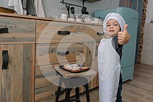 Young happy mom and her baby cook cookies at home in the kitchen. Christmas Homemade Gingerbread. cute boy with mother