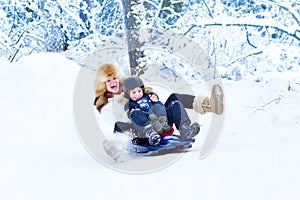 Young happy mother and her son on sleigh ride