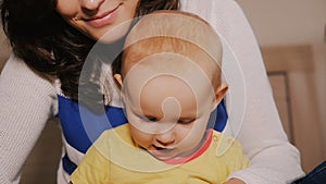 Young Happy Mother Holding her Newborn Child and throws up. Family at home. Beautiful smiling Mom and Happy Baby