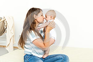 Young happy Mother playing with small baby