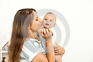 Young happy Mother playing with small baby