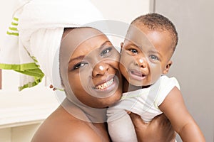 Beautiful mother with her baby after bathing in a white towel