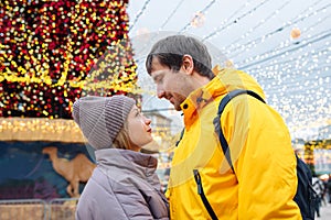 Young happy people enjoy Christmas in the city street. Christmas Holidays. Two lovers on Valentine's Day