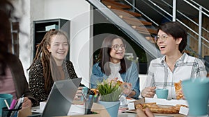 Young happy people office workers eating pizza and talking having fun in workplace