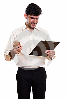 Young happy Persian businessman smiling and reading on clipboard