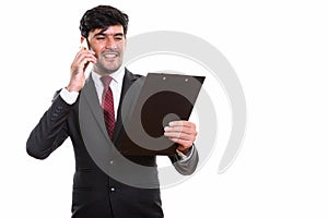 Young happy Persian businessman smiling and reading on clipboard