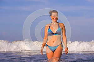 Young happy and playful red hair woman in bikini swimming on the sea playing with big waves enjoying Summer holidays paradise