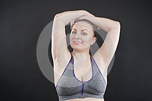 Young happy plus size caucasian woman shows her unshaved armpit