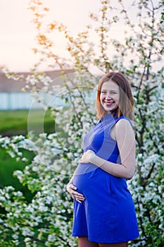 Young happy pregnant woman enjoying life in nature