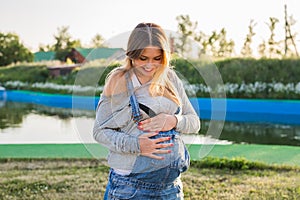 Young happy pregnant woman relaxing and enjoying life in autumn nature