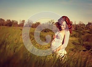 Young happy pregnant woman relaxing and enjoying life in nature.