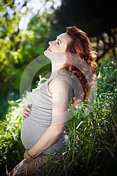 Young happy pregnant woman relaxing and enjoying life in nature.