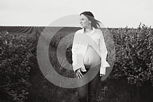 Young happy pregnant woman relaxing and enjoying life in nature. Outdoor shot. Copyspace