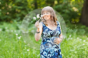 Young happy pregnant woman relaxing and enjoying life in nature. Outdoor shot. Copyspace