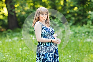 Young happy pregnant woman relaxing and enjoying life in nature. Outdoor shot. Copyspace