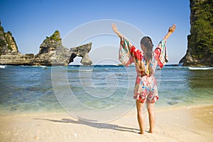 Young happy and pretty tourist Asian Korean woman in Summer dress enjoying tropical paradise beach holidays posing arms opened fre