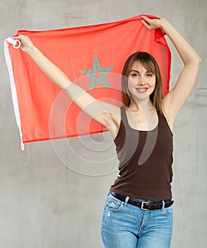 Young happy pretty woman displaying flag of morocco