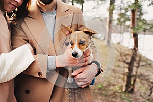 Young happy romantic couple walking together with jack russel terrier dog in autumn